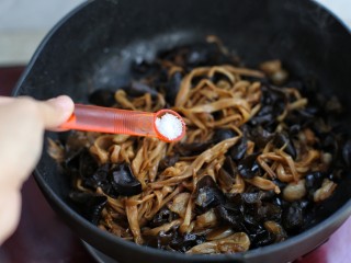 11、木耳黄花菜炒五花肉,待木耳啪啪作响时调入盐