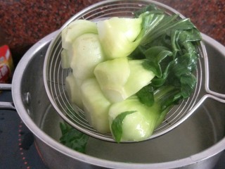 7、腊肠煲仔饭,煮一锅热水往锅里加一汤勺的植物油,青菜倒入焯一会捞出沥干备用