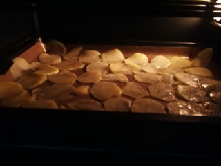 9、椒香薯片,烤盘铺油布或者锡纸。将扮好油的薯片均匀铺好。烤箱温度上火180下火160十五分钟。