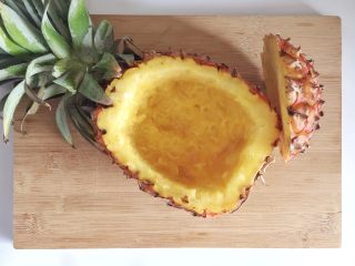 5、粗粮凤梨炒饭,凤梨皮留出厚度约2厘米，用刀和勺子把内部掏空，取出凤梨肉，制成凤梨碗。