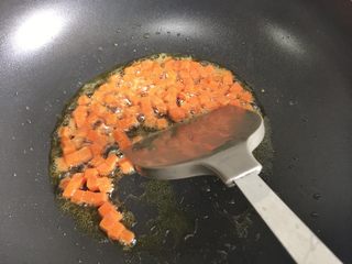 7、粗粮凤梨炒饭,开小火，锅内倒入少许油，加入胡萝卜丁翻炒。胡萝卜是比较硬的食材需要多炒一会儿，使β胡萝卜素溶于油，更利于营养吸收。
