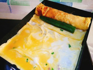 15、阳光早餐～秋葵厚蛋烧,卷起来 再放一个秋葵 继续卷 把剩余的蛋液再倒入锅中