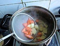 4、韩式安东炖鸡,锅中水烧开放入土豆和胡萝卜煮上2分钟捞出