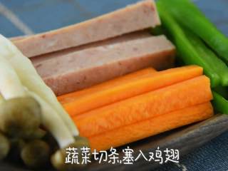 2、一道无骨时蔬鸡翅，不但荤素搭配，营养健康，而且外观很抢眼呢,午餐肉切条，蔬菜切条，塞入鸡翅。