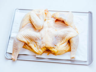 1、烤鸡,将鸡肉清洗干净，腹部一刀切开，去鸡脖、鸡头、鸡爪、鸡PP，展开如图所示（将一只鸡完全展开可以减少烘烤时间）﻿(鸡肉选择时三黄鸡、清远鸡也可，选择肉质鲜嫩的鸡肉，老母鸡一定不能选，烤熟了咬不动...)