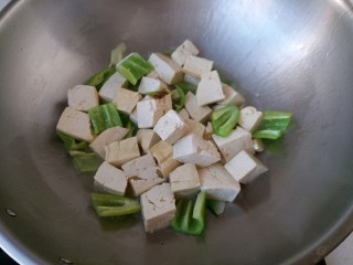 7、青椒溜豆腐,将焯过的豆腐块放入锅里