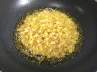 8、枸杞玉米烙,加入油，油量没过玉米粒，开中火继续炸三分钟左右，看见表皮酥脆成雪花状即可关火。