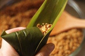 10、鲜肉棕,另取半张粽叶,覆盖在翻折后的粽叶表面;用以包裹裸露的米粒