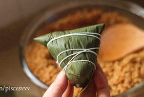 11、鲜肉棕,逆时针旋转90度,将粽叶弯出尖角,用绳子捆绑住即可
