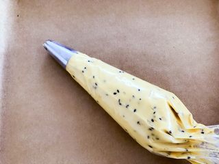 3、宝宝辅食：红薯芝麻曲奇,准备好红薯面糊和烤盘，烤盘上垫油纸，接下来开始挤曲奇。