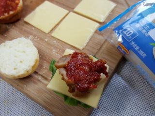 16、迷你汉堡,在鸡腿肉上再涂抹番茄酱，盖上另一片汉堡胚用牙签固定好，我完成了。