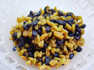 7、葡萄干红糖欧包,利用发酵的空挡把葡萄干和黑加仑淘洗干净。用凉水泡软变膨胀起来后，沥干水分备用。