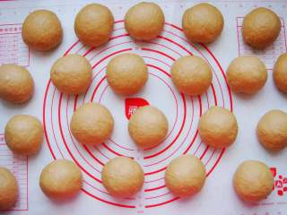 9、葡萄干红糖欧包,把面团放在垫子上平均分成100克一个的小剂子，排气揉圆。