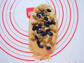 10、葡萄干红糖欧包,面团擀长条状，底部边缘处用手指按薄点。铺上葡萄干，轻按几下。