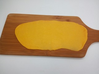 10、最爱面包+奶香南瓜面包棒,案板上撒一些面粉防粘,将一个醒发好的小面团压扁,并用擀面杖擀成长条形