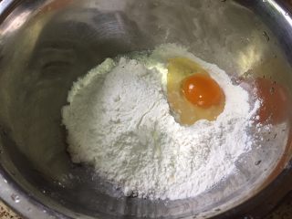 2、葱香芝士卷饼,然后，再把鸡蛋打入到面粉中；