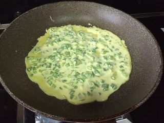 5、葱香芝士卷饼,热锅，可以放入少许的油，也可以不放，因为是不粘锅；把面糊倒入锅里，晃动下，让铺满锅底；