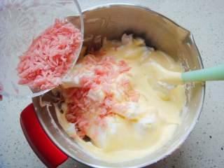 13、红柚果粒蛋糕,呈“J”字形翻拌，不可划圈避免消泡。翻拌均匀后倒入剩下的蛋白中。撒入三红柚果粒。