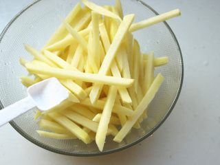 9、炸薯条,加入一勺盐。