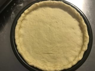 6、秘制芝心卷边披萨,将饼皮移入披萨盘内，没有披萨盘就放烤盘里。