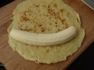 8、燕麦香蕉卷,取一去皮香蕉放面皮上