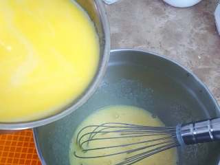 4、无敌巨好吃の奶酪华夫饼,混合牛奶液与蛋液。左手将牛奶液缓慢、少量多次的倒入蛋液中，同时右手蛋抽一直搅打蛋液，注意避免一次性倒入太多以致烫熟蛋液。