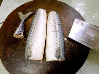 2、盐煎青花鱼,切去头部，切断尾部，从脊背处横刀分切成两半。