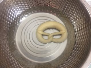 9、德国碱水面包普雷结,冷冻好后戴手套把面团在碱水中浸泡20秒,反面也泡20秒捞出