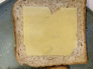 2、芥末芝士火腿三明治,先铺上一片金凯利成熟切达干酪片