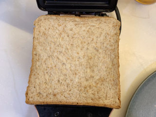 8、芥末芝士火腿三明治,放入烤面包机里，盖上慢慢烤至芝士融化