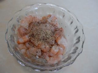 3、黄金虾仁炒饭,虾线去除好后过一下清水后用厨房纸巾拭干后放入碗里,加入料酒、黑椒碎和盐拌匀后放入冰箱冷藏10分钟