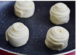 14、油旋,用手按扁，边按边旋转饼坯，直到成为薄薄的圆饼。