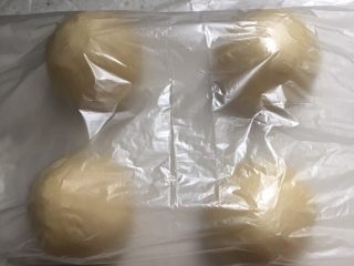 9、椰蓉花朵面包,松弛好的面团分四份,揉圆后盖保鲜膜松弛10分钟