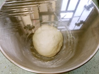 6、酥皮苹果小餐包,把面团揉圆，放入厨师机，盖上保鲜膜，置于温暖湿润的环境进行一发。