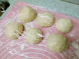 14、酥皮苹果小餐包,接下来包包子。把发酵好的面团按压排气后，分成6个大小相若的小面团，盖上保鲜膜，松弛20分钟。