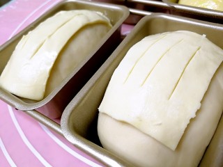 19、酥皮苹果小餐包,发至1倍大，把酥皮切成面包胚表面大小，盖在表面，用刀尖纵向切割几下。烤箱预热180度。