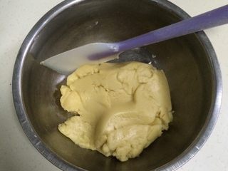 6、桃酥饼干,用刮刀翻拌均匀，直至无干粉状态。