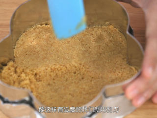 5、蓝莓益力多慕斯,把混合好的饼干碎倒进去包好底的慕斯圈里面,铺平,然后用刮刀把饼干碎压平压紧压实,饼干底就做好了,然后把饼干底送入冰箱冷藏室凝固一下备用