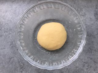 6、南瓜玫瑰卷,继续揉面,揉成不软不硬适中光滑的面团,盖上保鲜膜进行第一次发酵