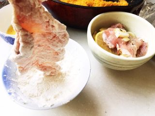 10、几乎无油的“炸”猪排,处理大排。拎起来！放入面粉，泡个面粉浴。泡完了记得拎起来再抖动一下。让面粉均匀的裹在大排身上。