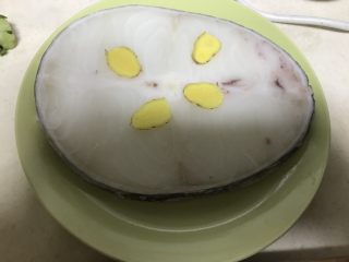 2、香煎银鳕鱼,放上姜片解冻，非常薄的一层薄冰