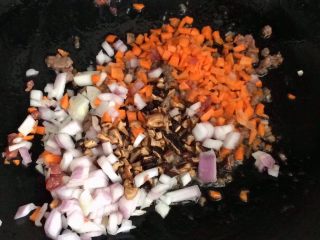 8、儿童牛肉香菇肉酱,接着放洋葱末,胡萝卜,香菇末炒出香味。