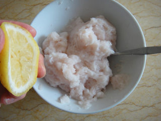 3、松仁鱼米,放入碗中加入盐，白酒 ，挤入柠檬汁拌匀后捞起鱼泥往碗中摔打至有粘性用手轻按明显感觉有弹性，静置15分钟