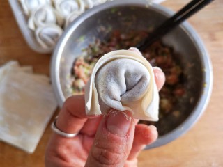 14、抱蛋馄饨——每天叫你的不是梦想,是早餐!,两只手分别捏住馄饨皮的角,向中间靠拢,然后捏紧,一个馄饨就包好了。