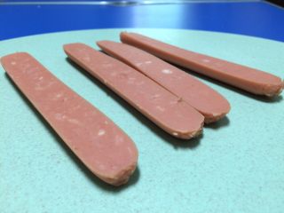 4、早餐美味鸡蛋灌饼,接下来把火腿肠一开二切成两半