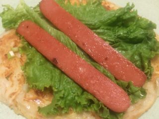 21、早餐美味鸡蛋灌饼,刷匀辣酱之后放入葱花和香菜，火腿肠，卷起来就可以了