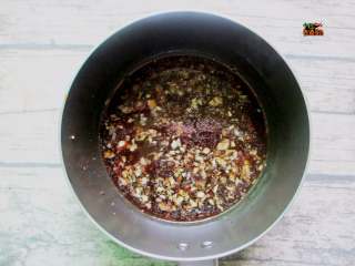 5、手撕蒜泥茄子,放入调味料，醋相对较多，和酱油约3:1的比例，不喜欢酸的可以少放些醋，除了生抽之外再放少许盐，还可以放半勺白糖调味。调好汁水后，可以先尝尝味道，最后再加一勺辣椒油，小火煮开晾凉