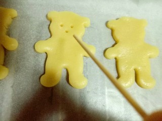 10、小熊抱杏仁饼干,用牙签扎出小熊的眼睛和鼻子，如图。