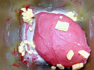 2、心相印红丝绒麻薯软欧,混合搅拌均匀揉成精光滑面团,能拉出厚膜后加入黄油。