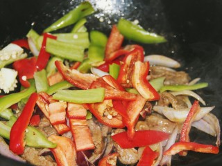 16、铁板黑椒牛柳,炒一分钟左右，再放入红彩椒和青椒炒